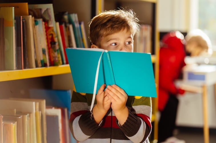 boy-holding-a-book-in-the-library-2026-03-25-07-25-29-utc